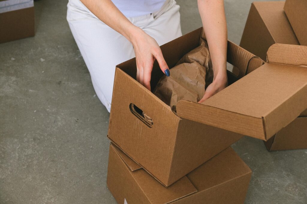 A woman is unpacking a delicate object in her new house; in the concept of moving to Romford